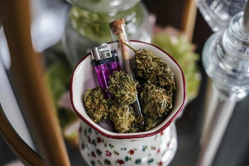 Premium PK Trophy cannabis buds with a lighter, glass pipe in a decorative bowl.